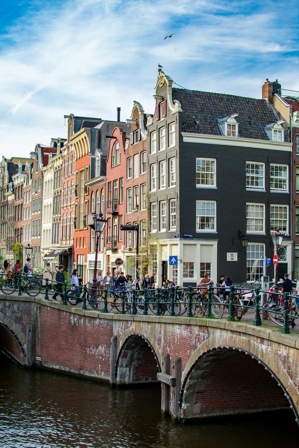 a group of people riding bikes on a bridge over a river