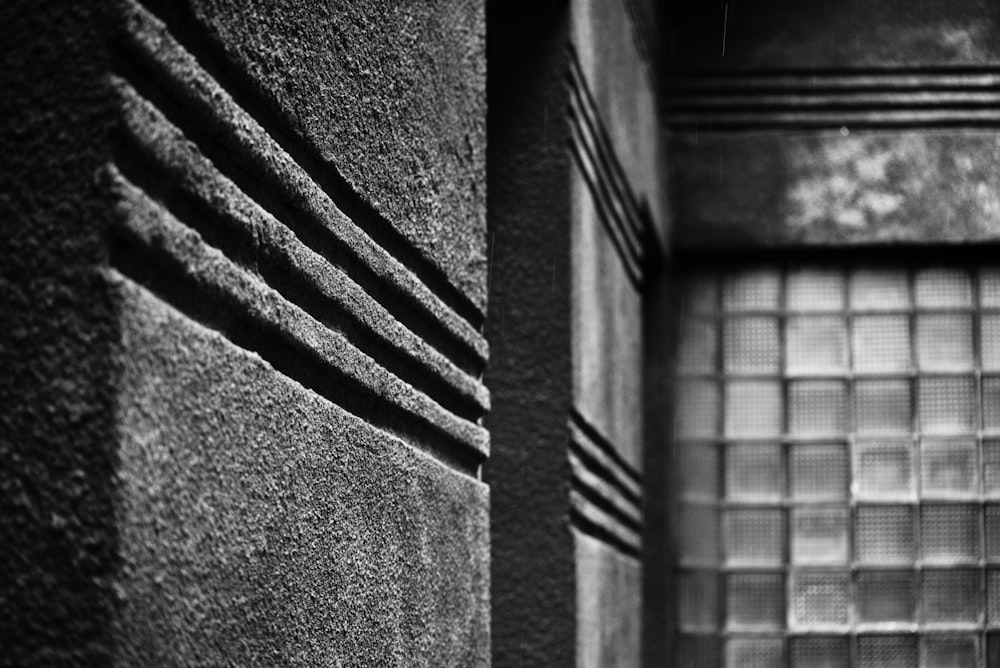 a black and white photo of a window and a wall