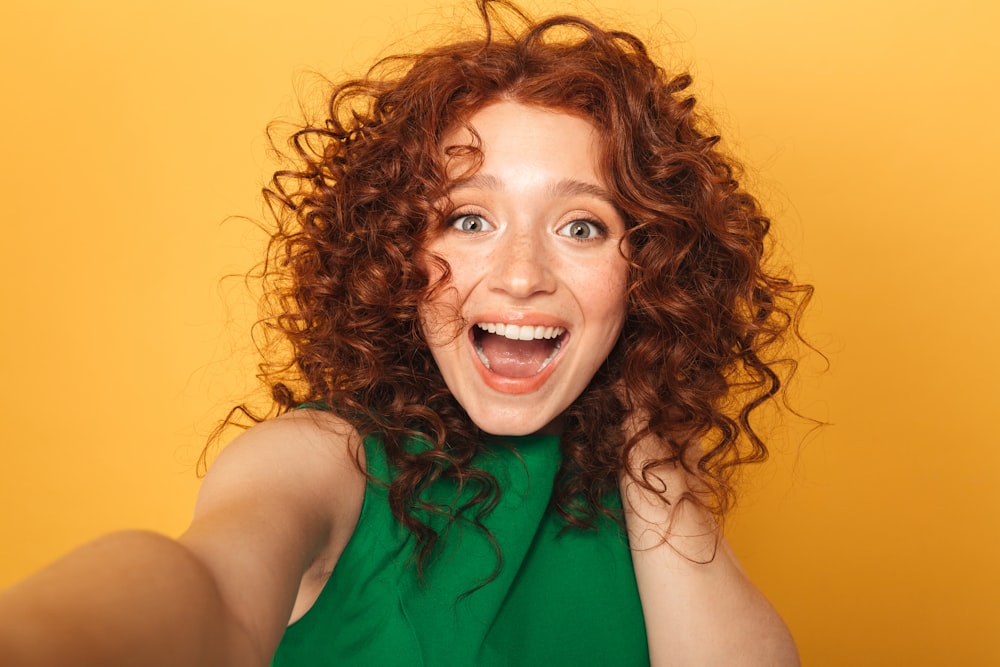 Una donna con i capelli ricci sta facendo una faccia buffa