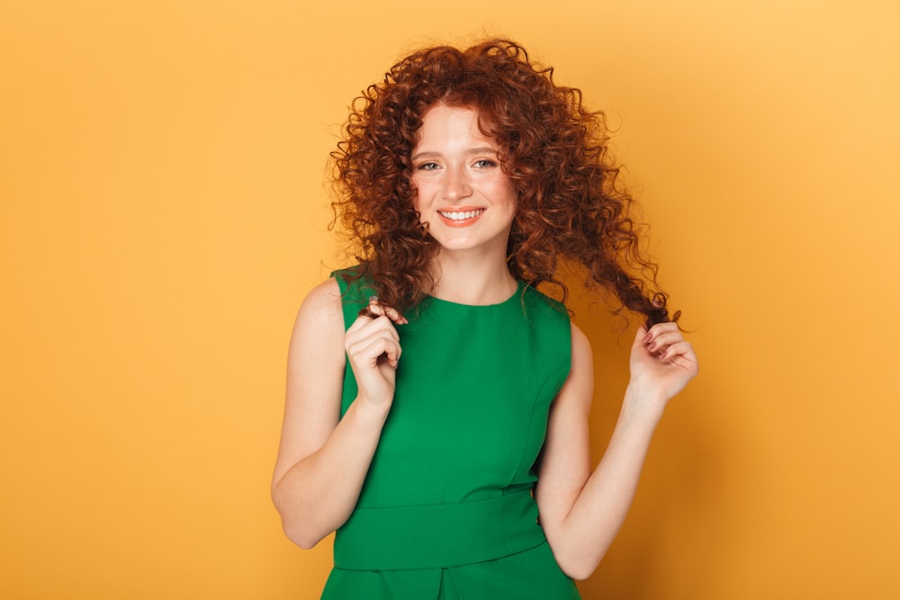 a woman in a green dress holding a hair brush