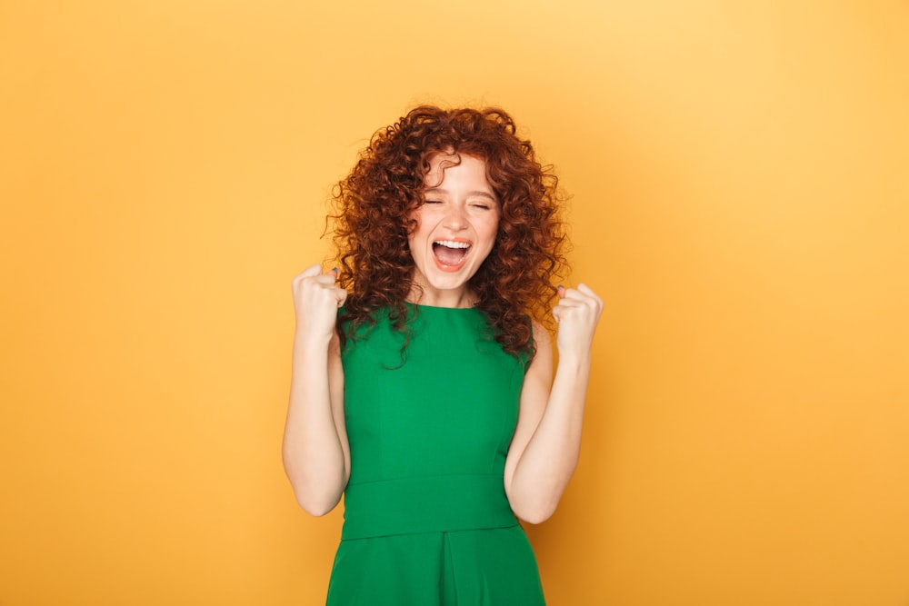 Una donna in un vestito verde sta ridendo