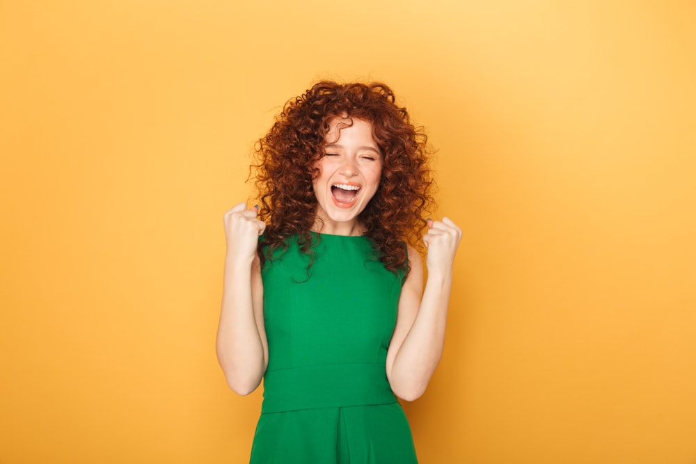 a woman in a green dress is laughing
