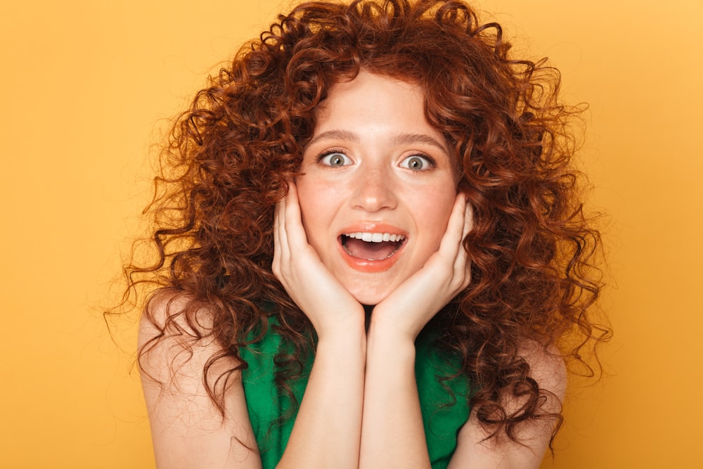 a woman with curly red hair is posing for a picture