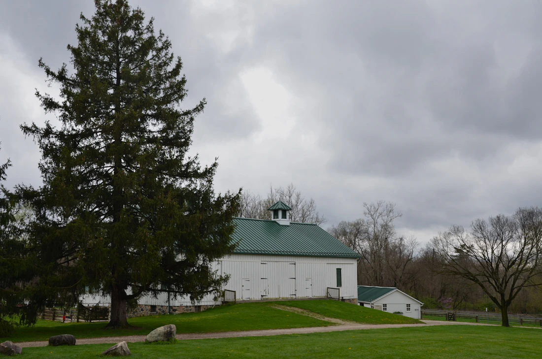 Traditional green and white bank barn — barndominium style