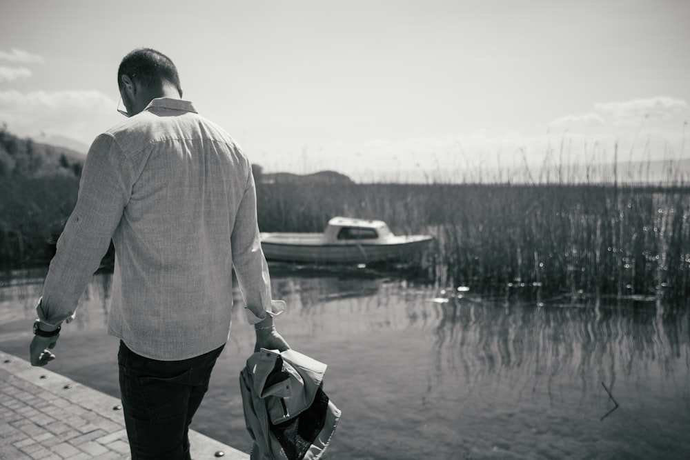 a man is walking along a dock near a boat
