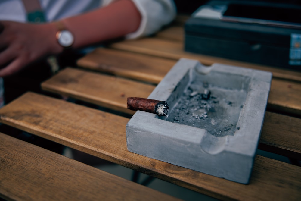 a person sitting at a table with a cigarette in a box