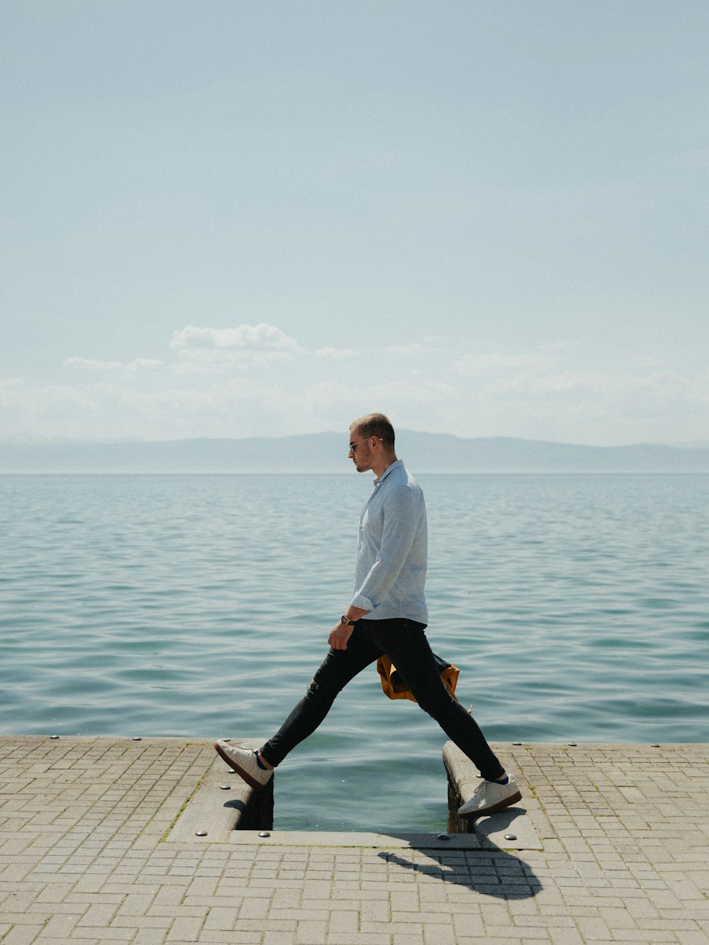 a man walking along the edge of a body of water