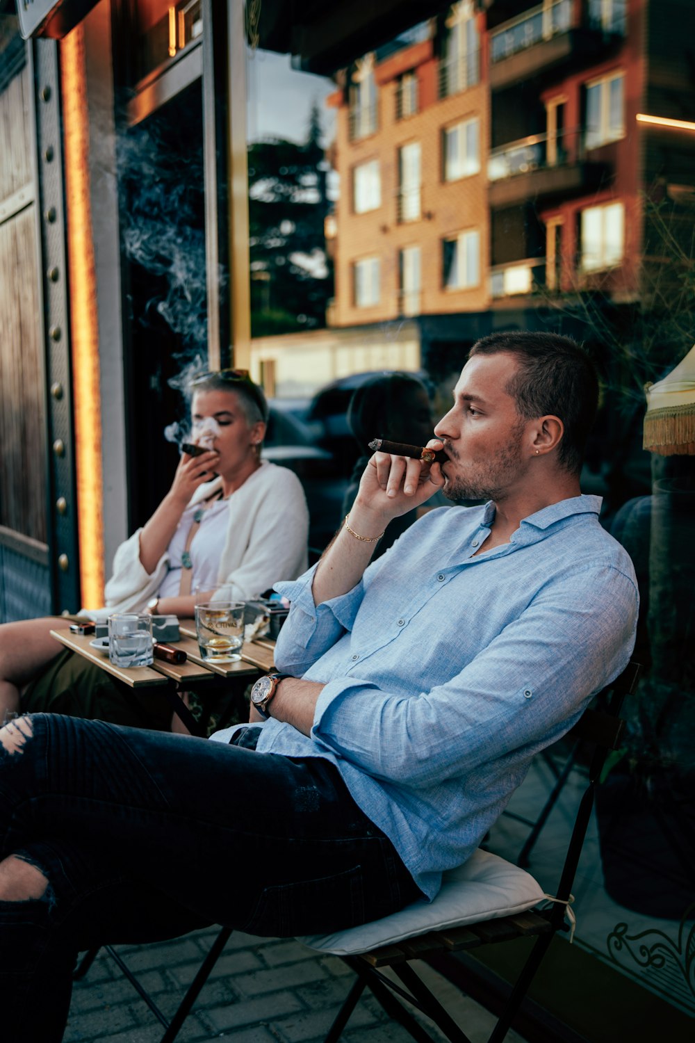 a man and a woman sitting at a table talking on cell phones