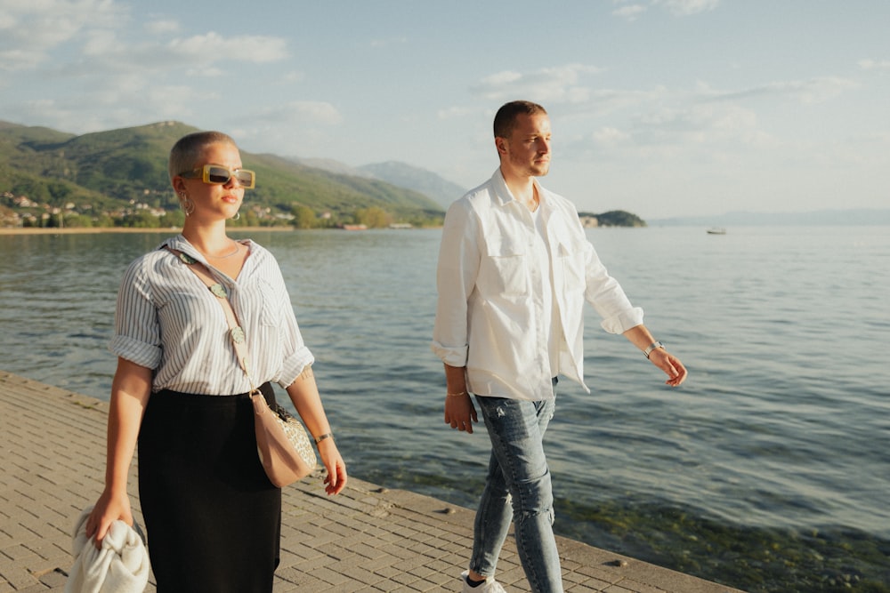 a man and a woman walking along a pier