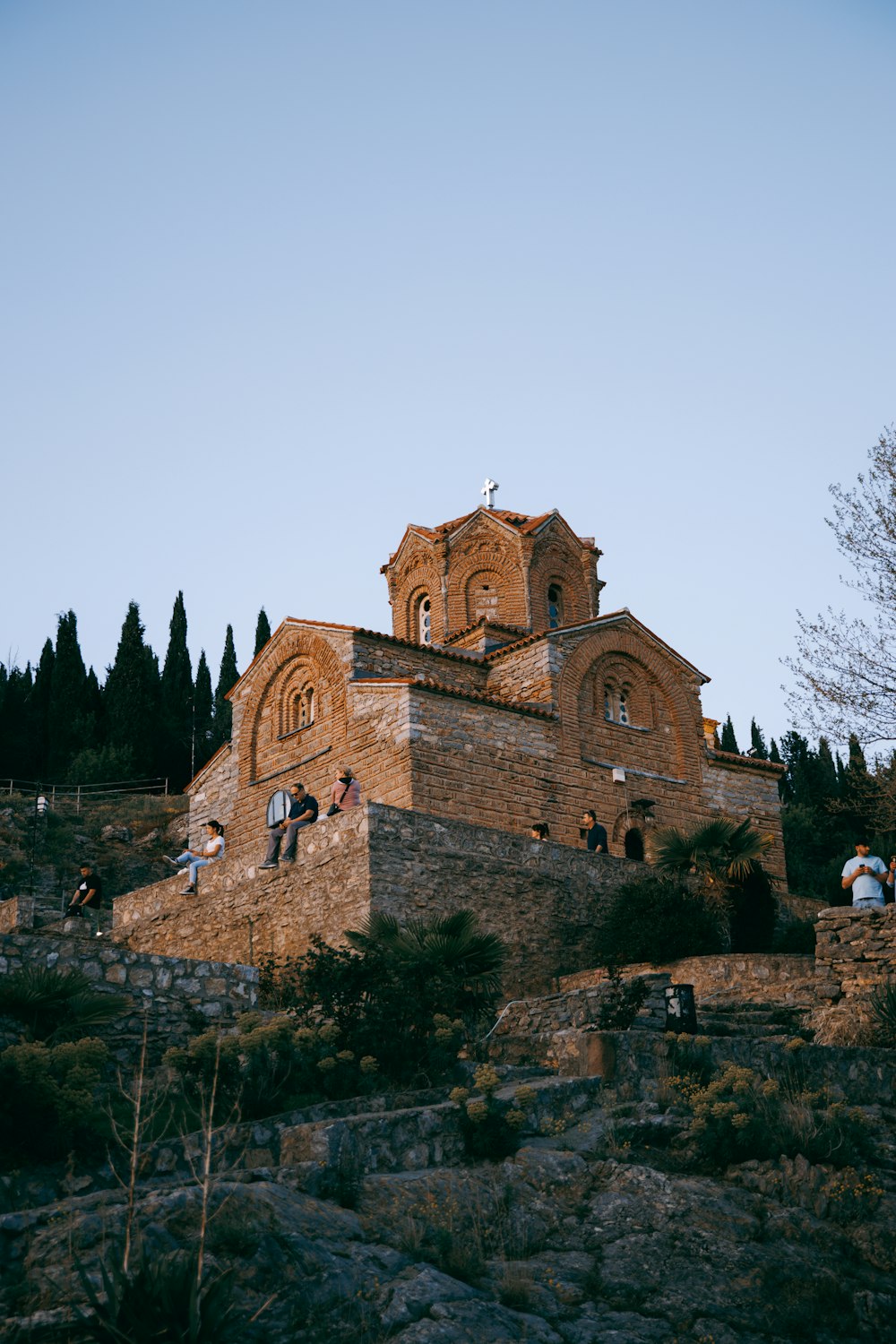 a group of people standing on top of a stone building