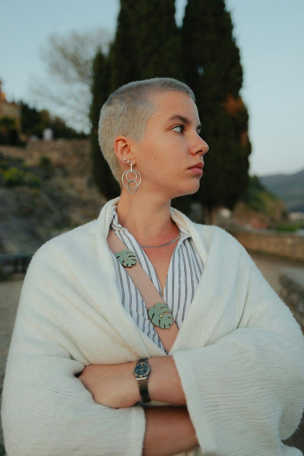 a woman with her arms crossed wearing a sweater