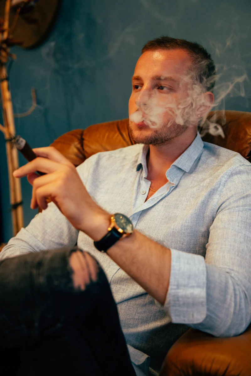 Member relaxing in a leather armchair with a cigar