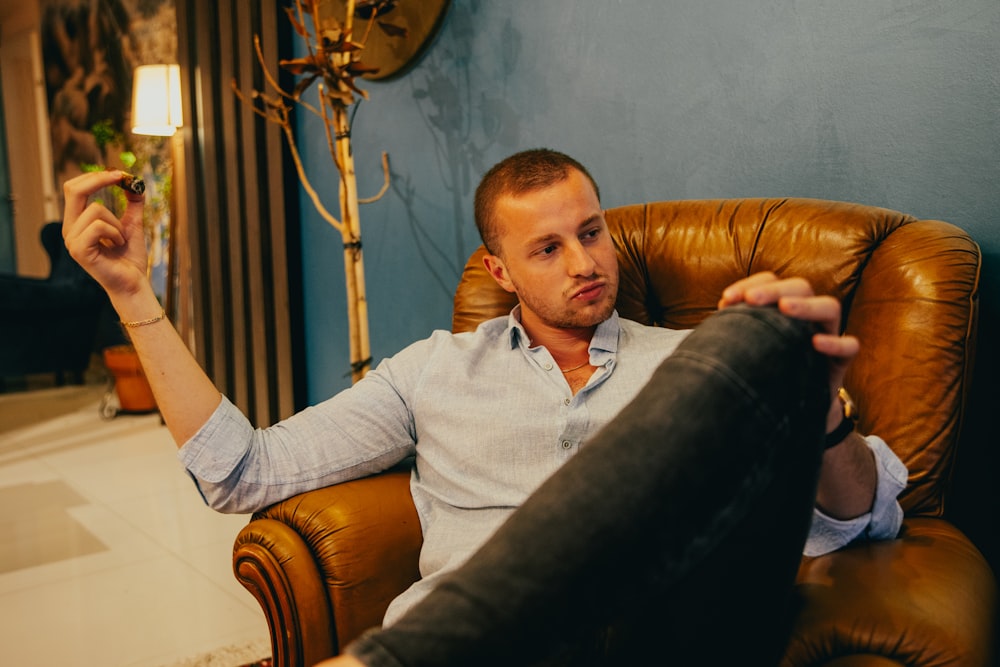 a man sitting in a chair holding a remote