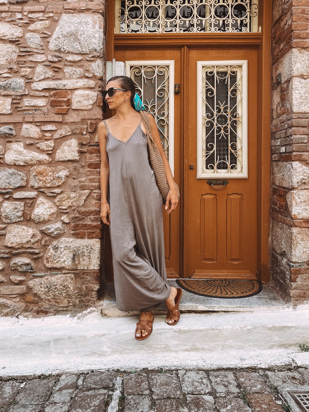 a woman standing in front of a brown door