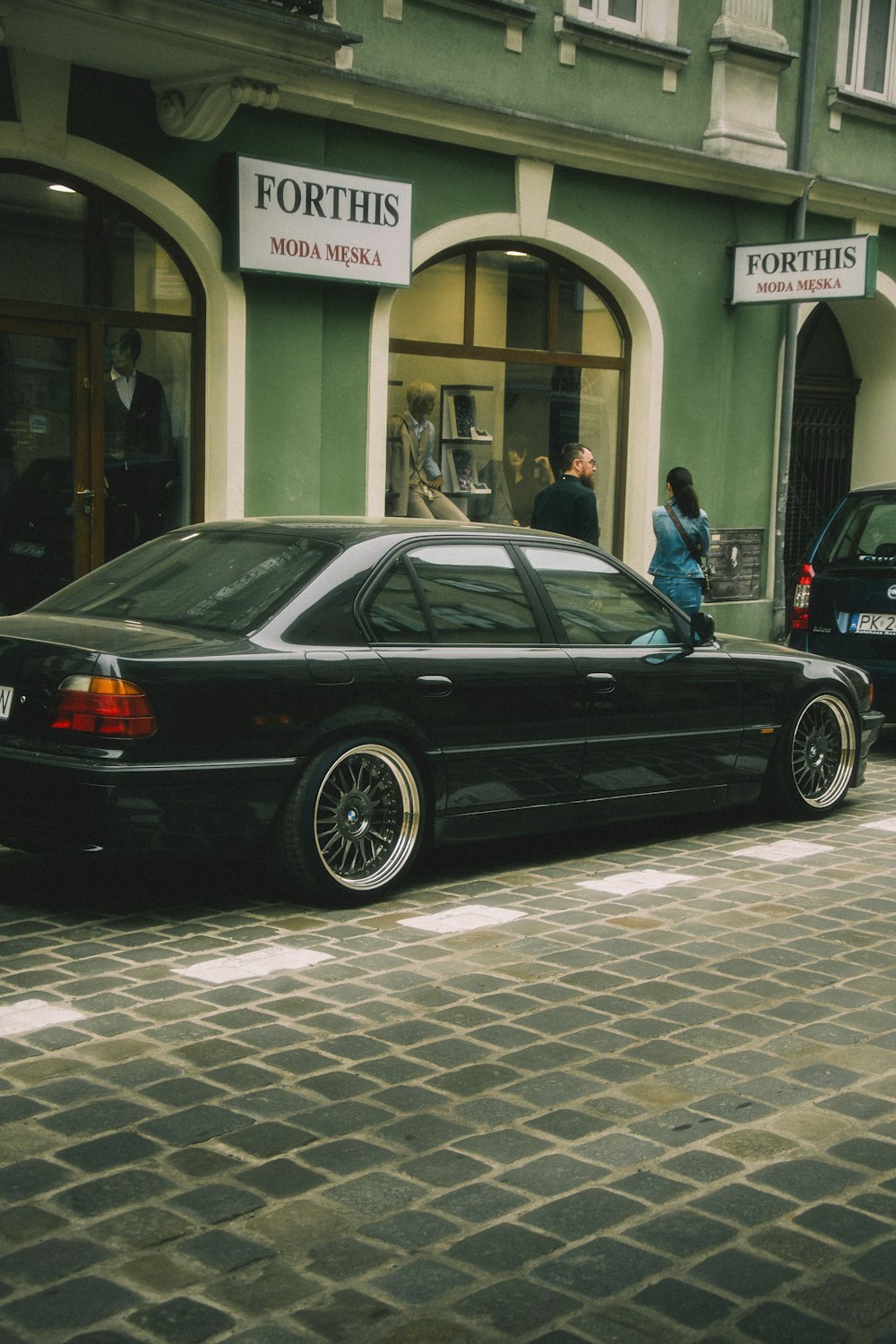 a black car parked on the side of a street