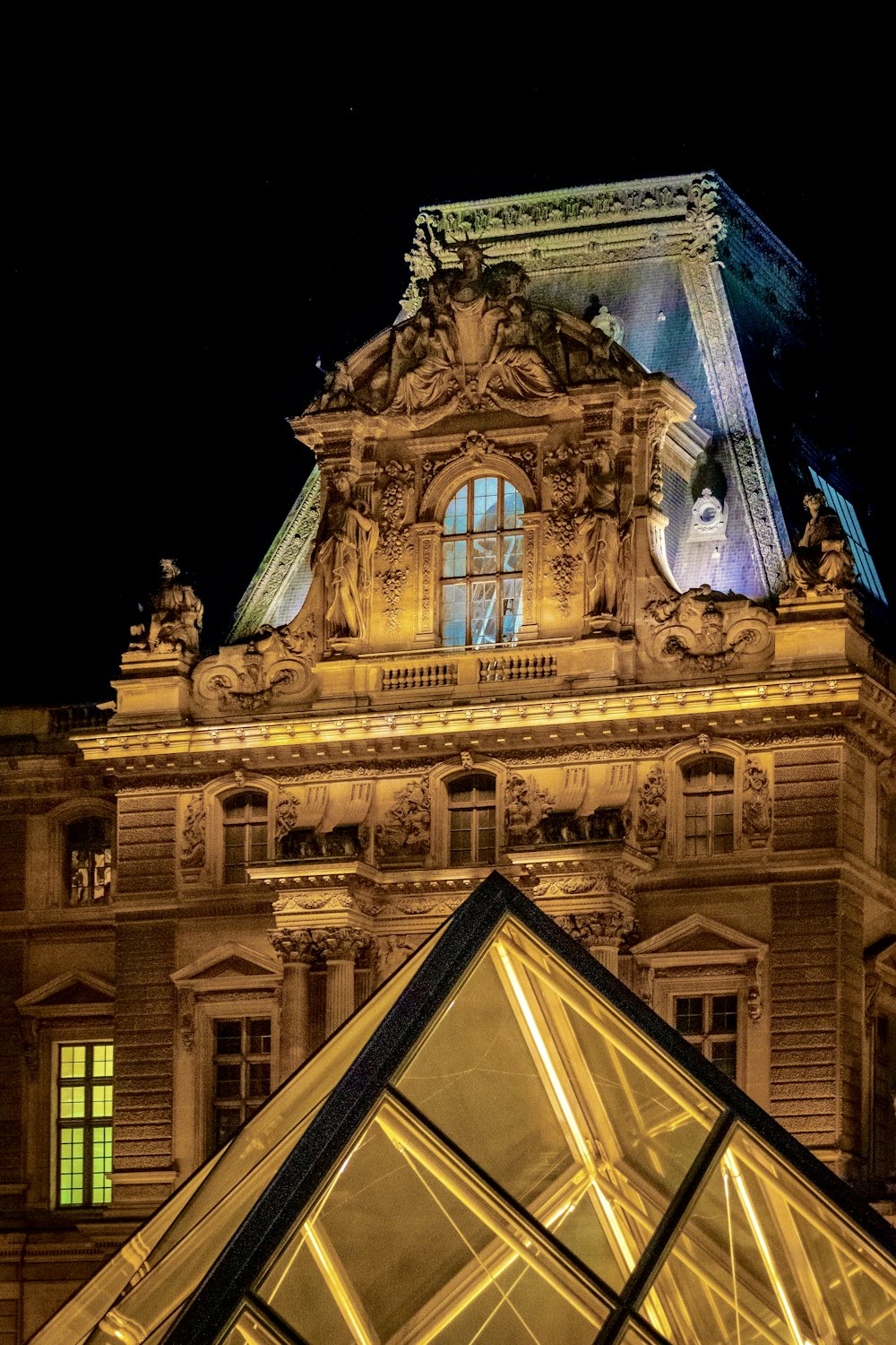 un edificio alto con una piramide di vetro di fronte