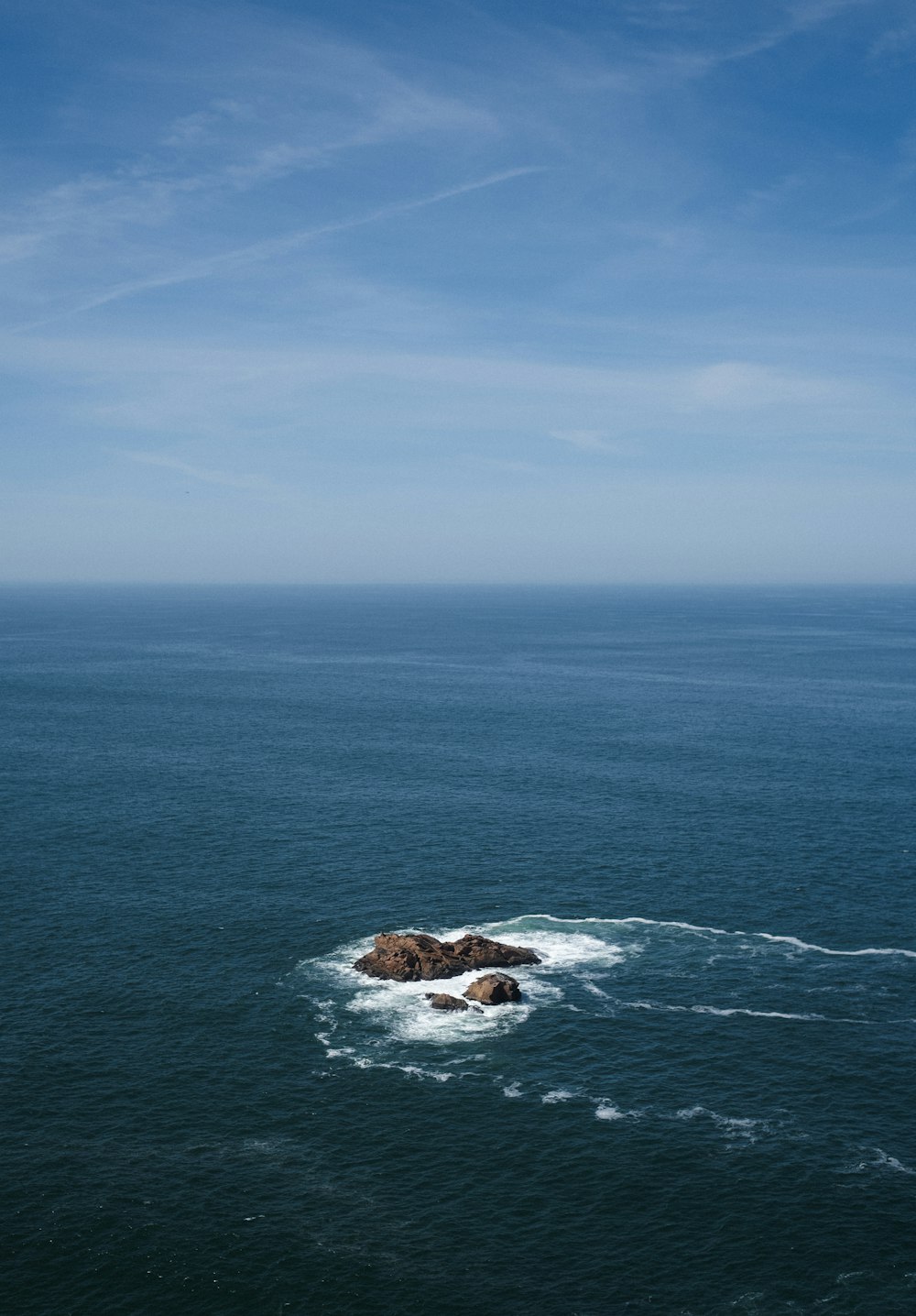 a large body of water with a rock in the middle of it