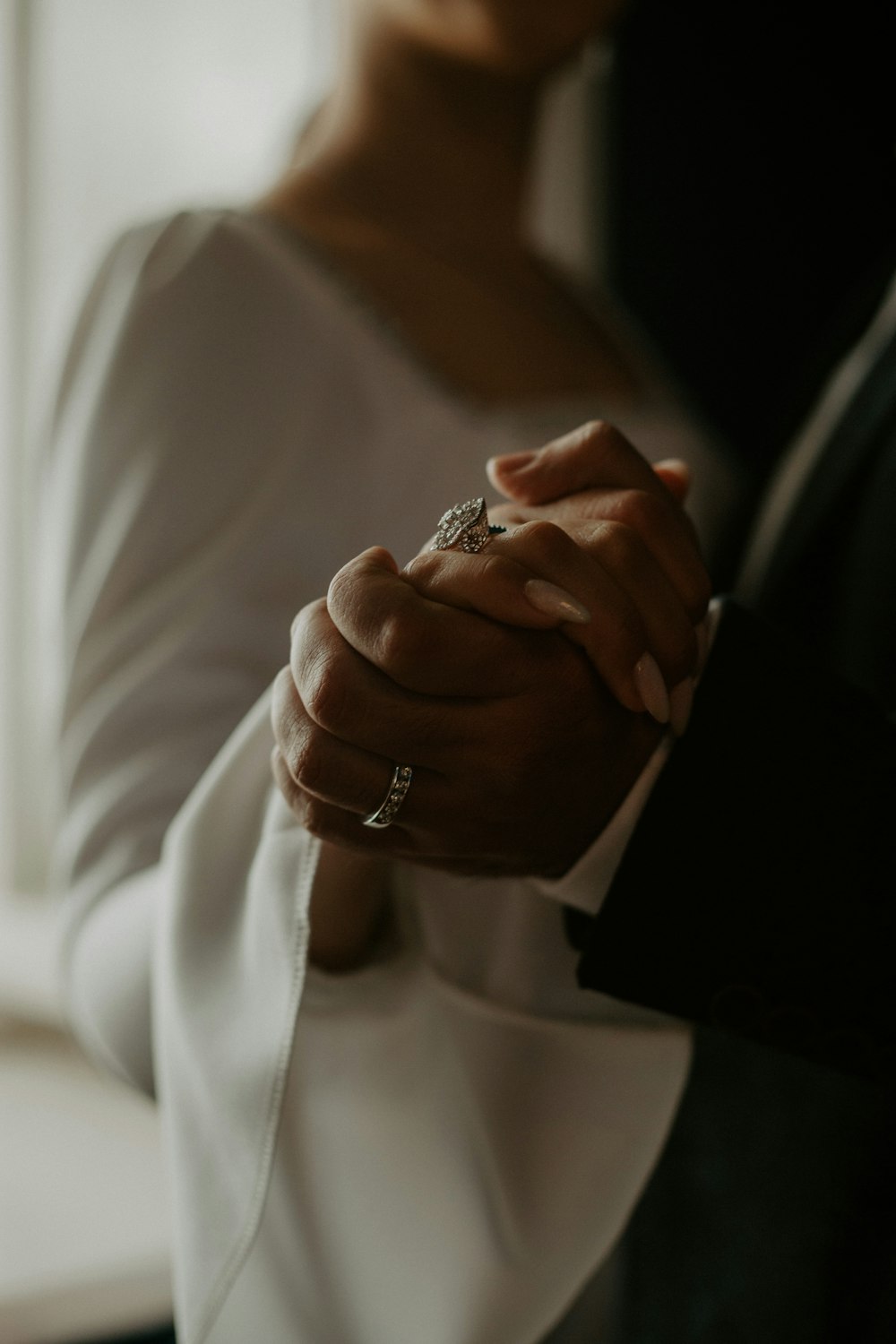 a close up of a person holding a wedding ring