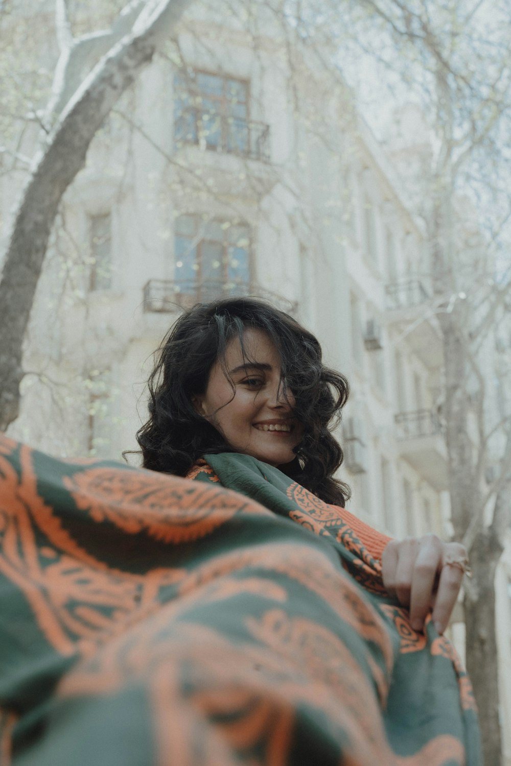 a woman wrapped in a blanket in front of a building