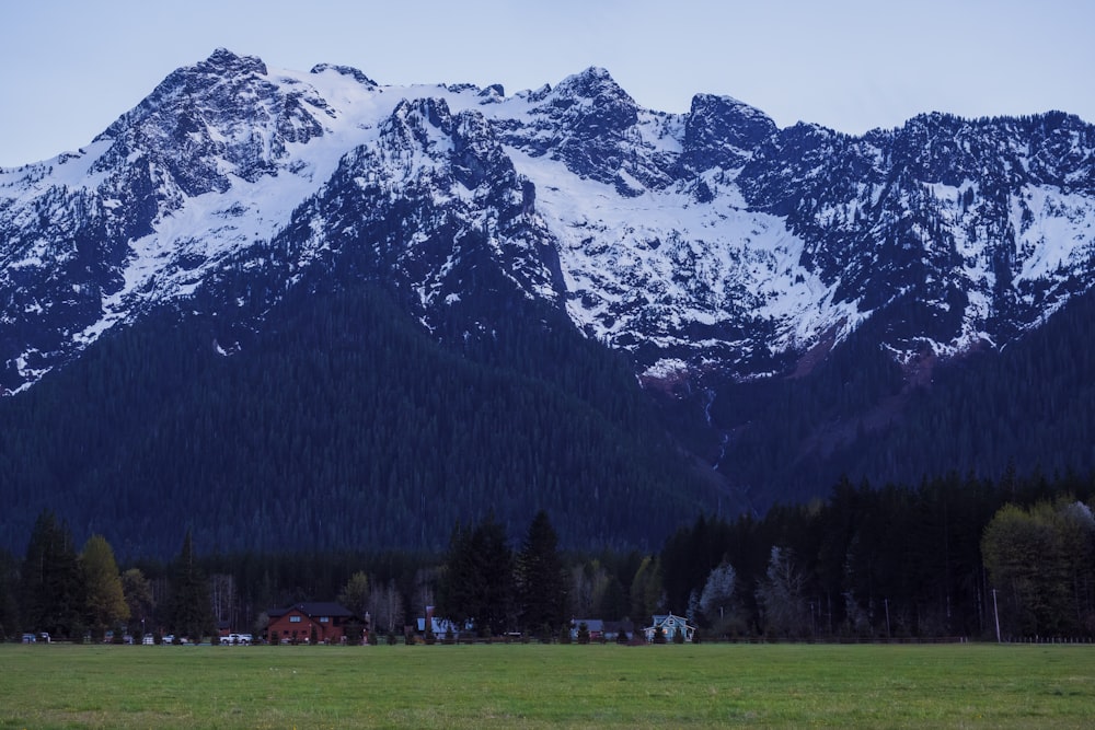 a large mountain range with a house in the foreground