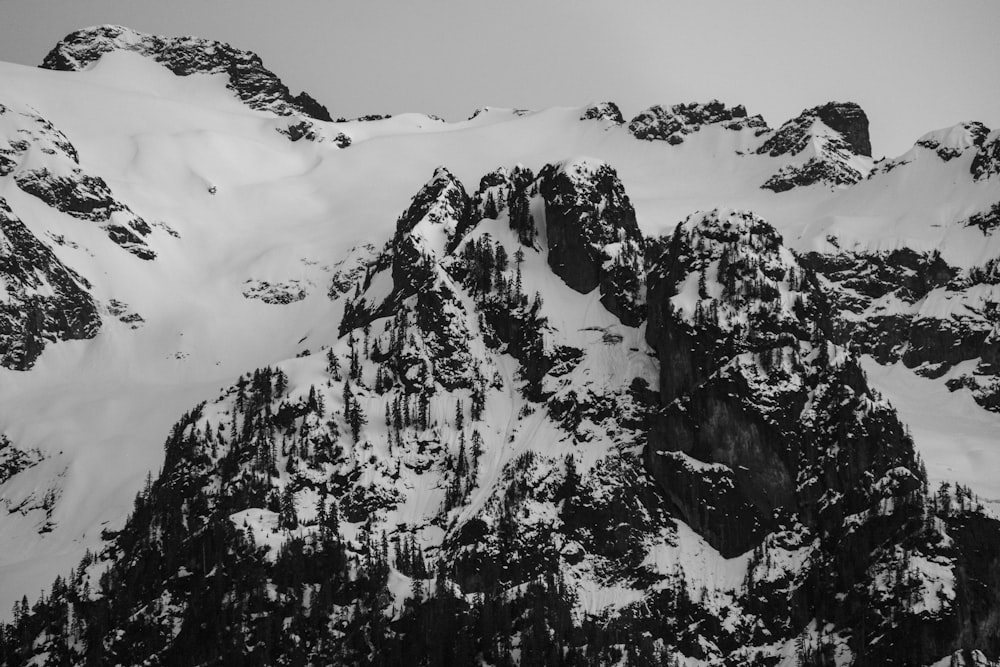 a black and white photo of a snow covered mountain