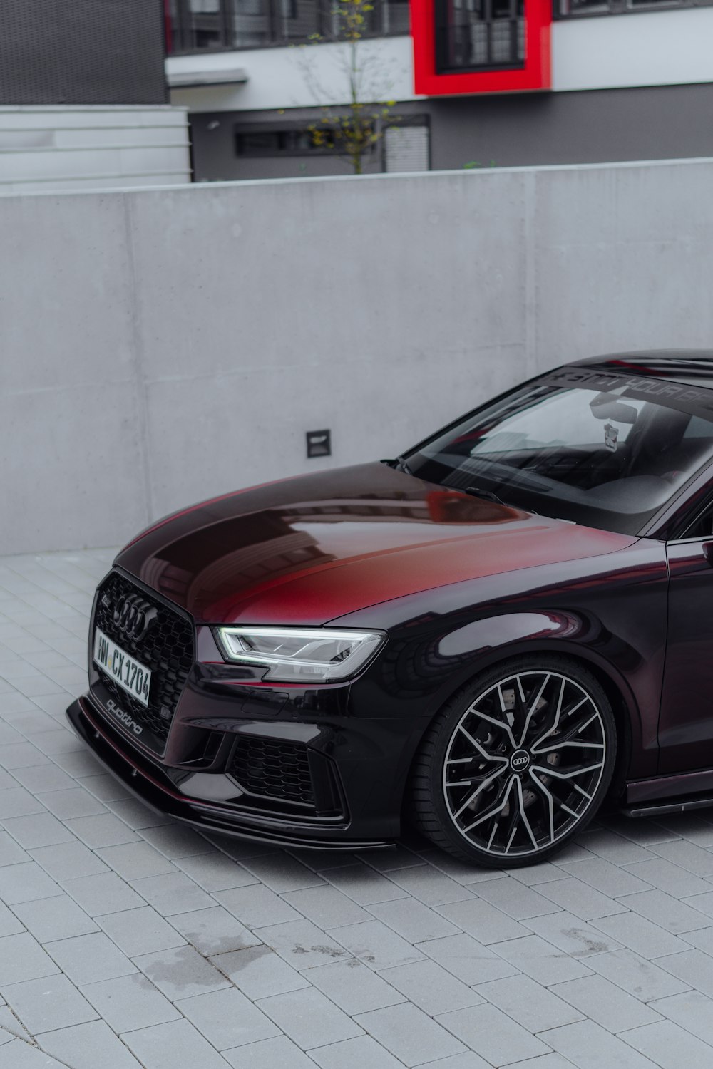 a black and red car parked in front of a building