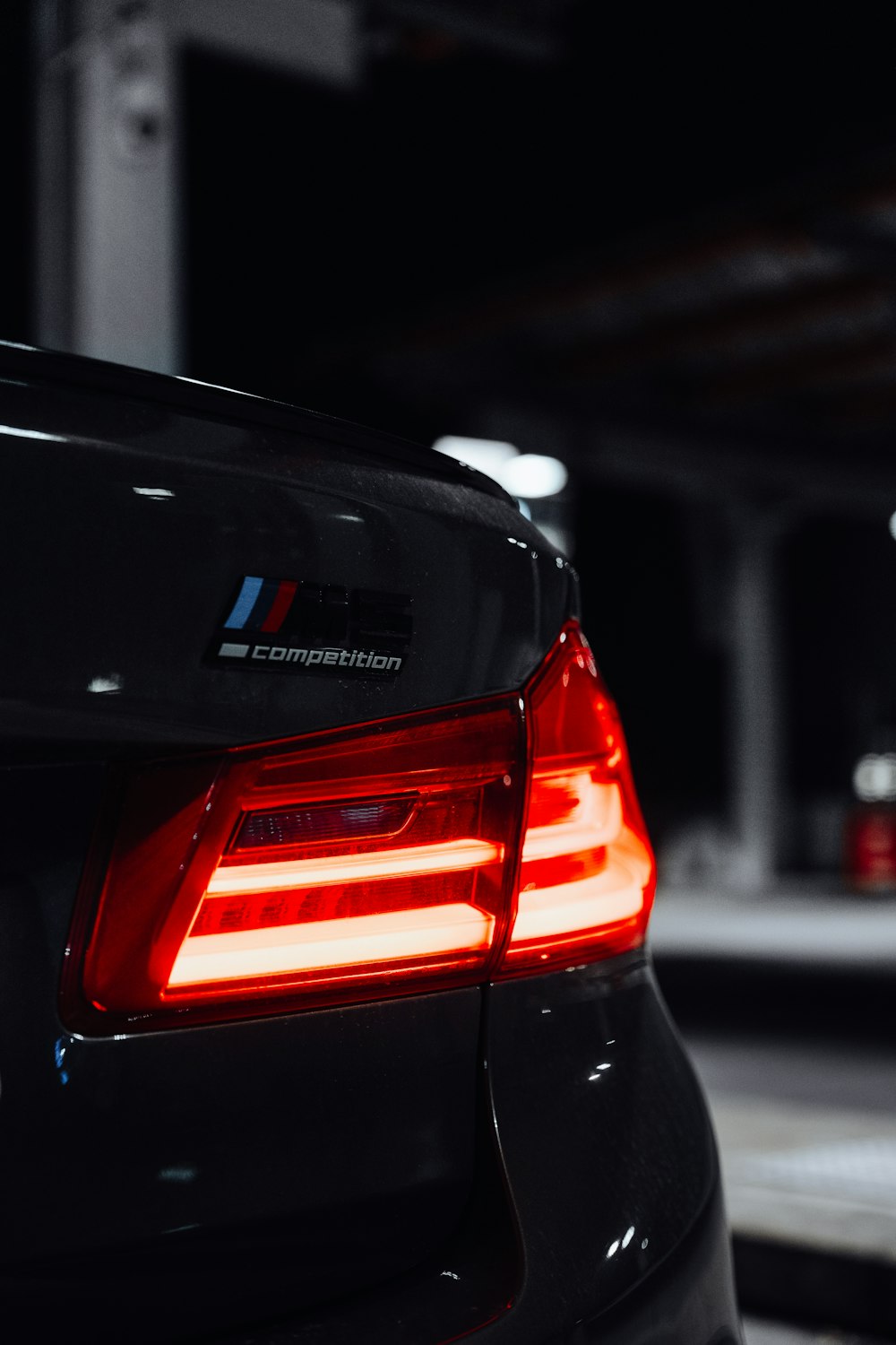 the tail lights of a bmw car in a parking garage