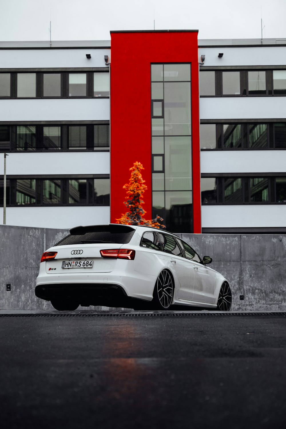 a white car parked in front of a red building