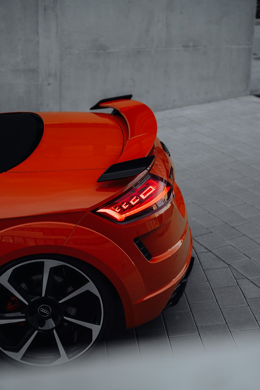 an orange sports car parked in a parking lot