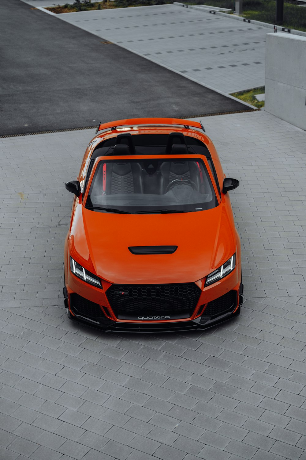 an orange sports car parked in a parking lot