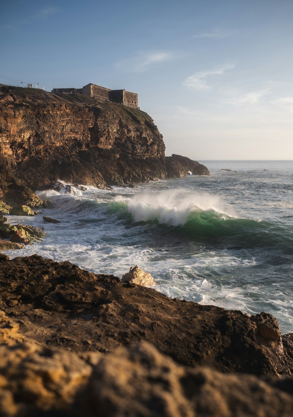 a large body of water next to a rocky cliff