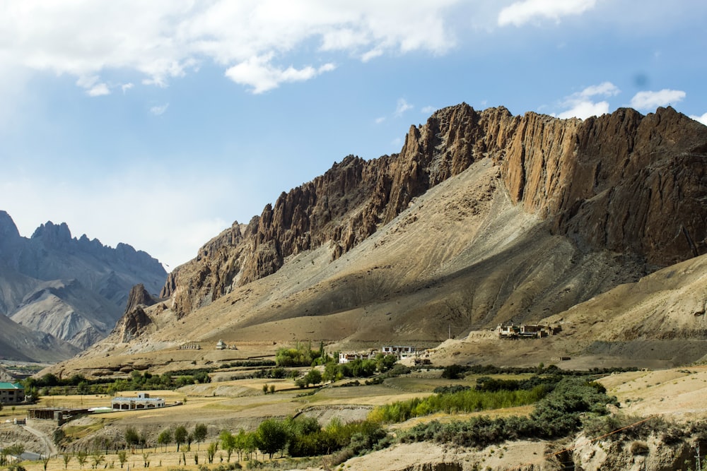 a scenic view of a valley with mountains in the background