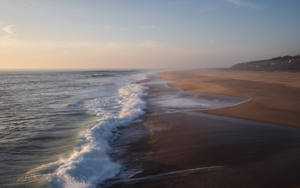 a view of a beach with waves coming in to shore