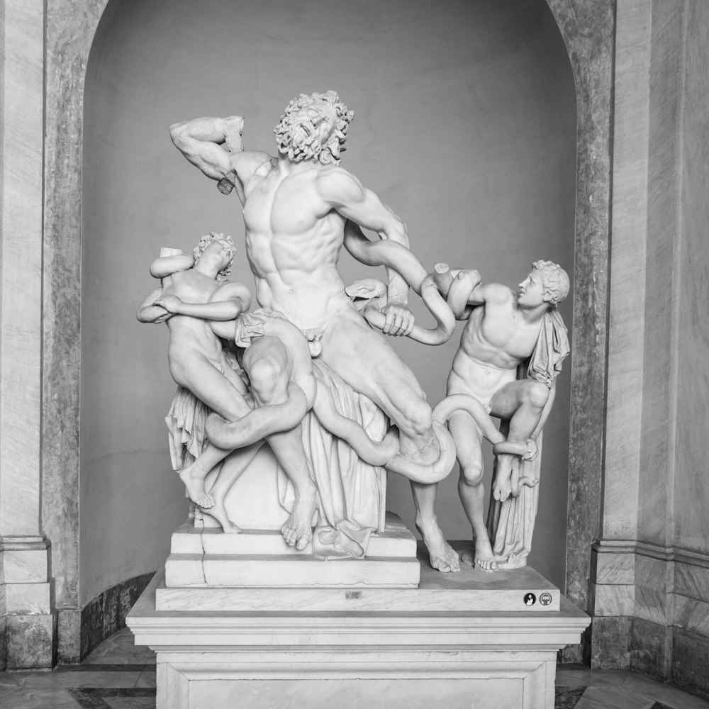 une photo en noir et blanc d’une statue d’un homme entouré d’hommes
