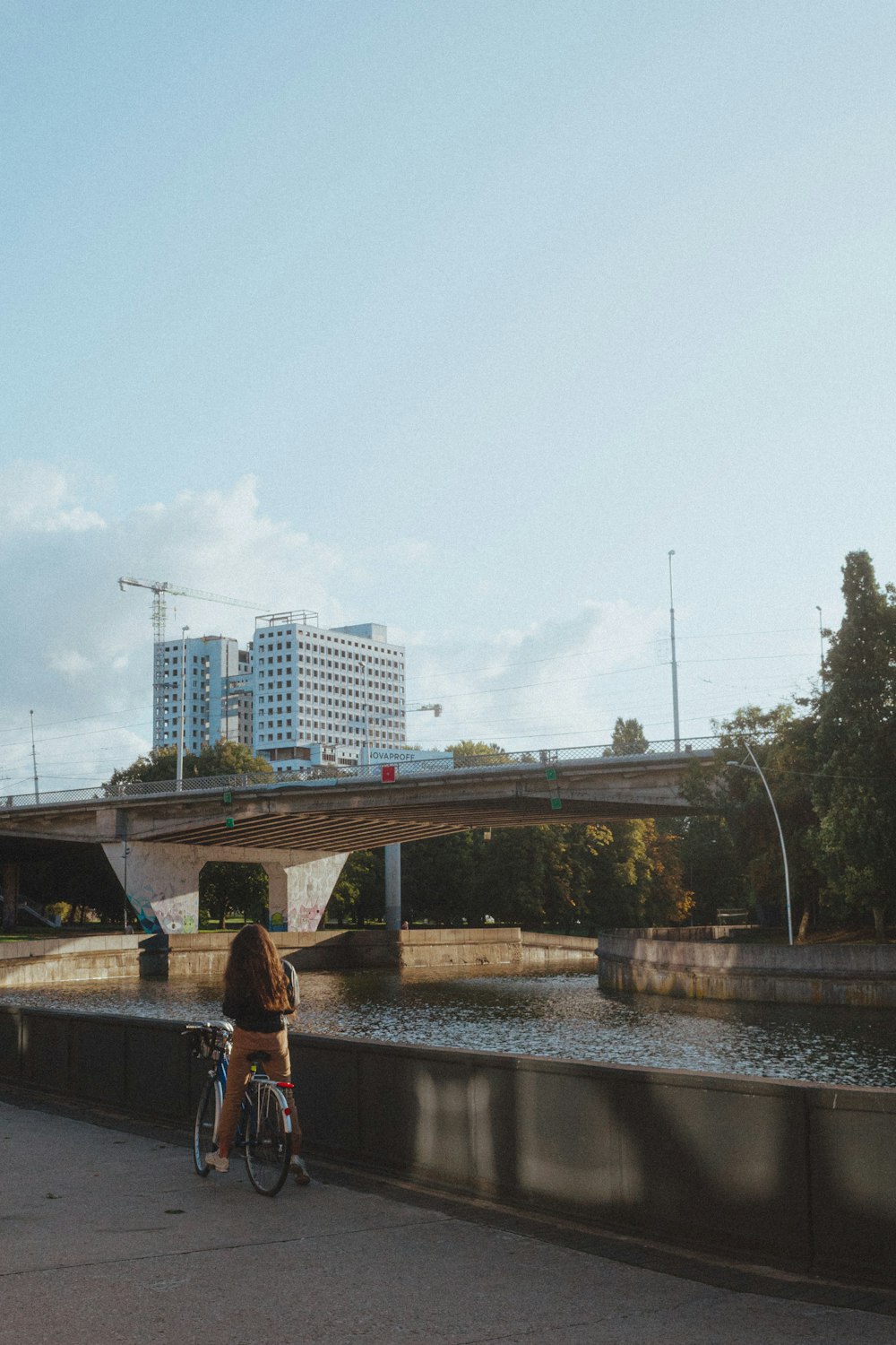 a person riding a bike on a bridge over a river