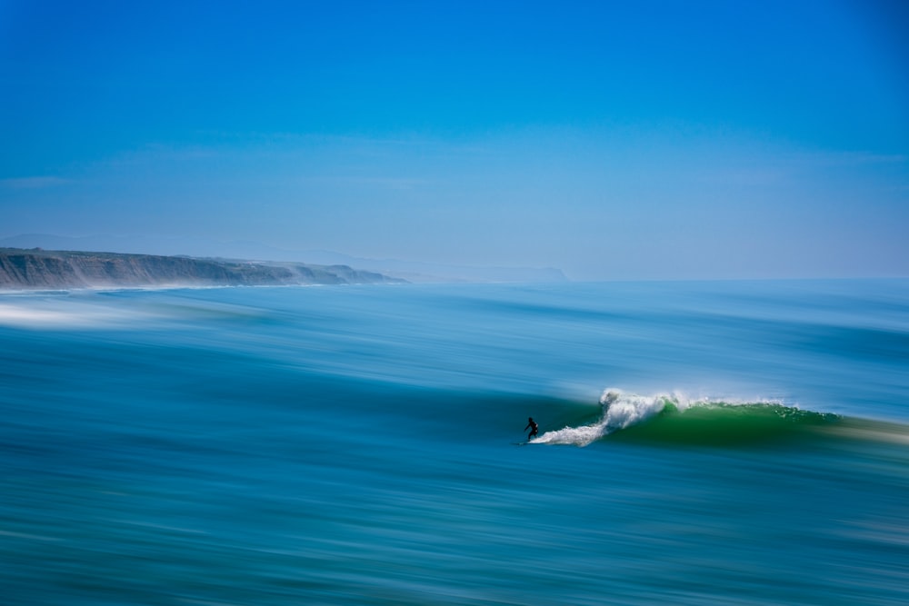 a person riding a wave on top of a surfboard