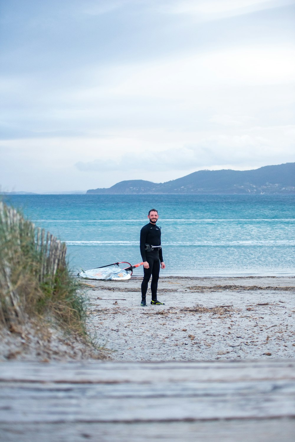 a man in a wet suit standing on a beach