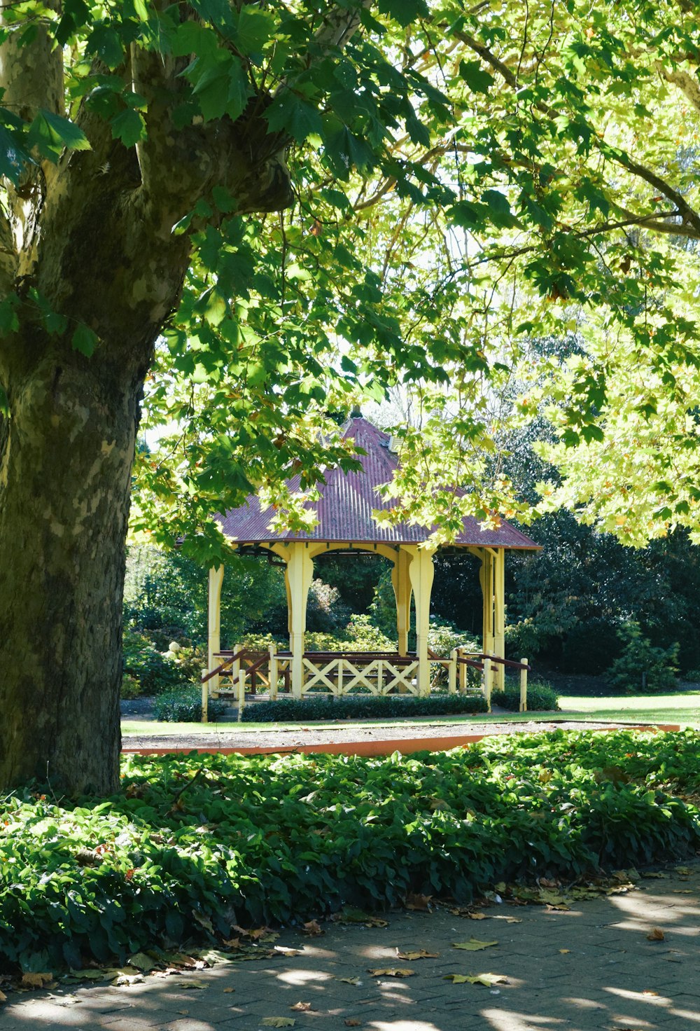 a gazebo in the middle of a park surrounded by trees