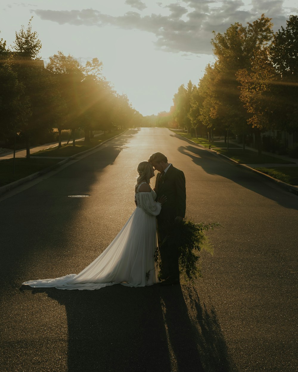 a bride and groom standing in the middle of a street