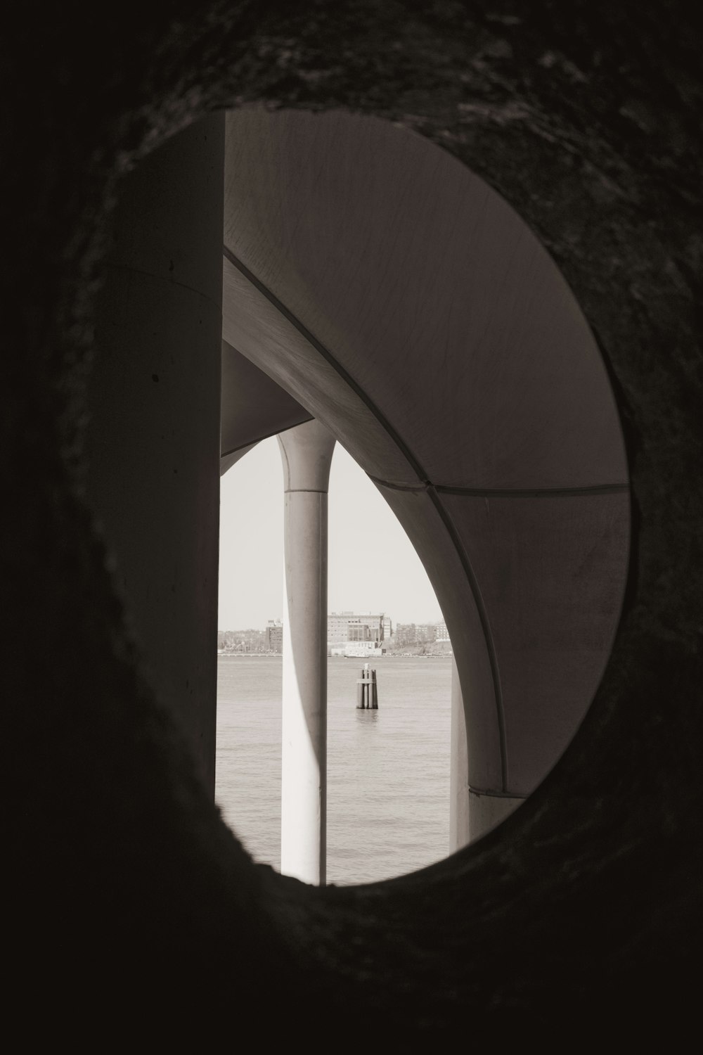 a view of a body of water through a tunnel
