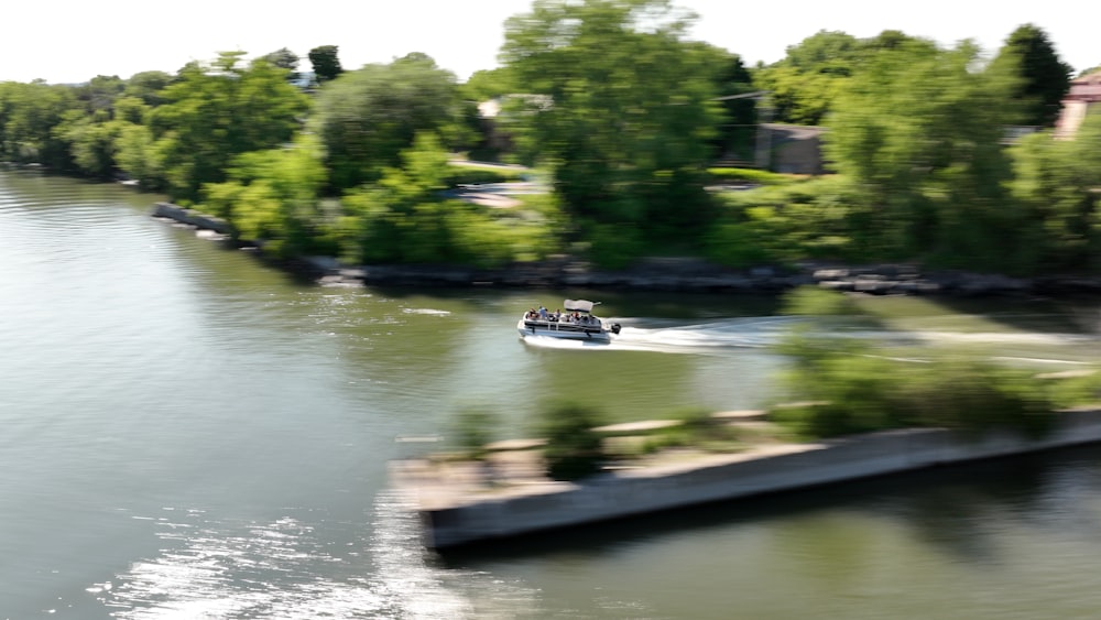 a boat traveling down a river next to a forest