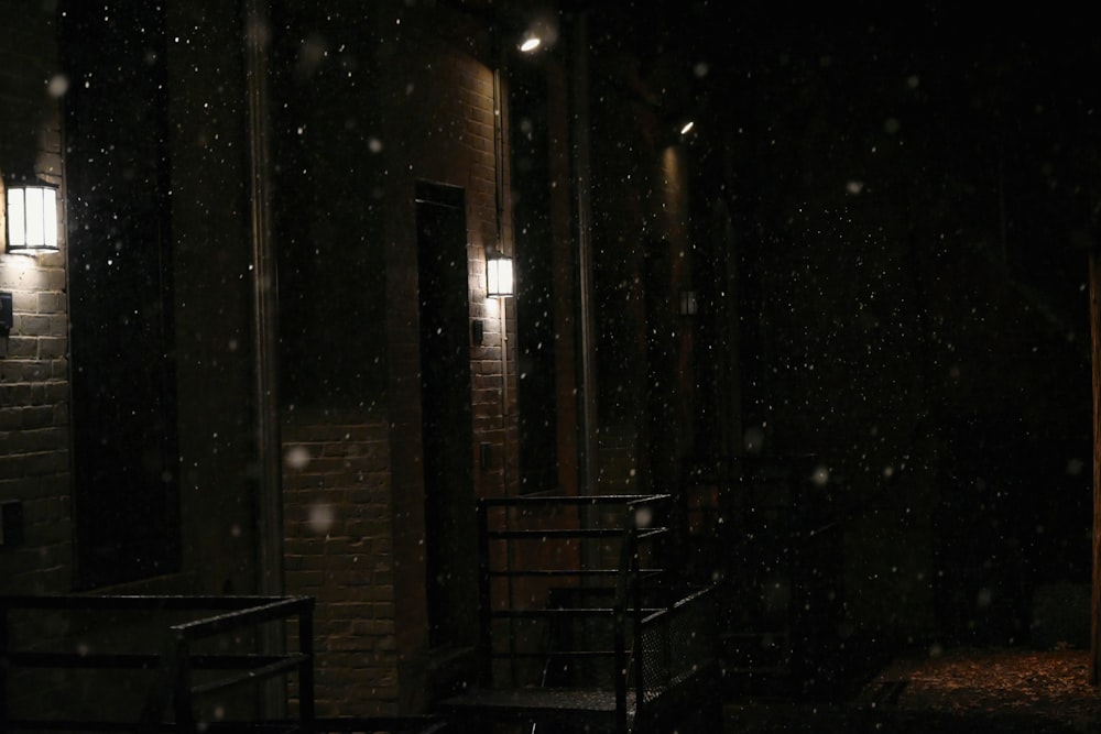a dark room with a light on and snow falling on the floor