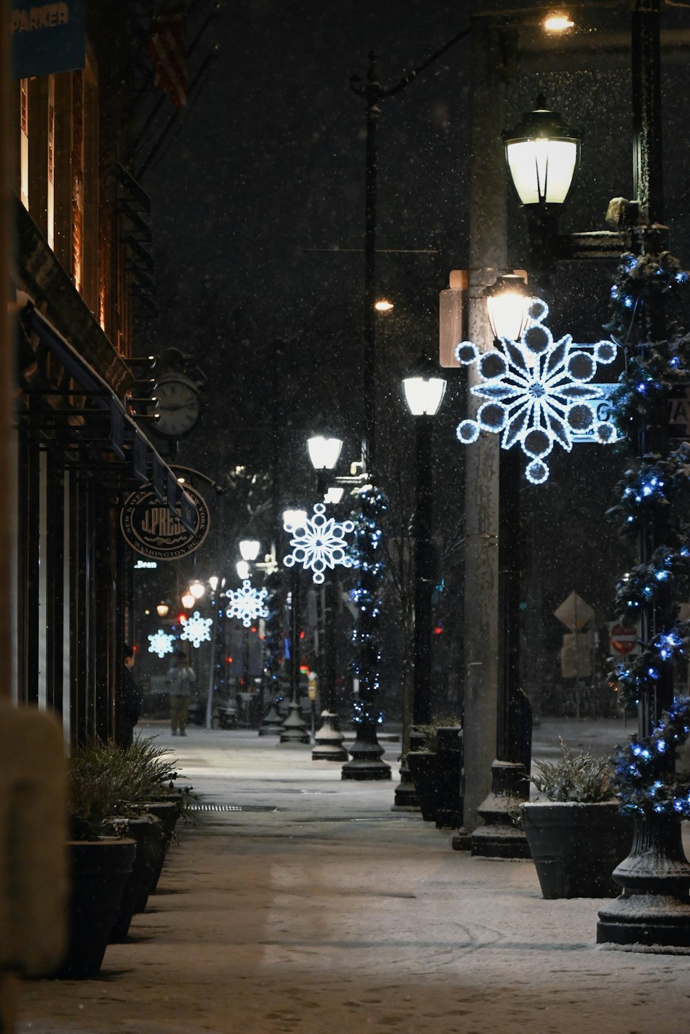 a snowy street at night with street lights and a snowflake