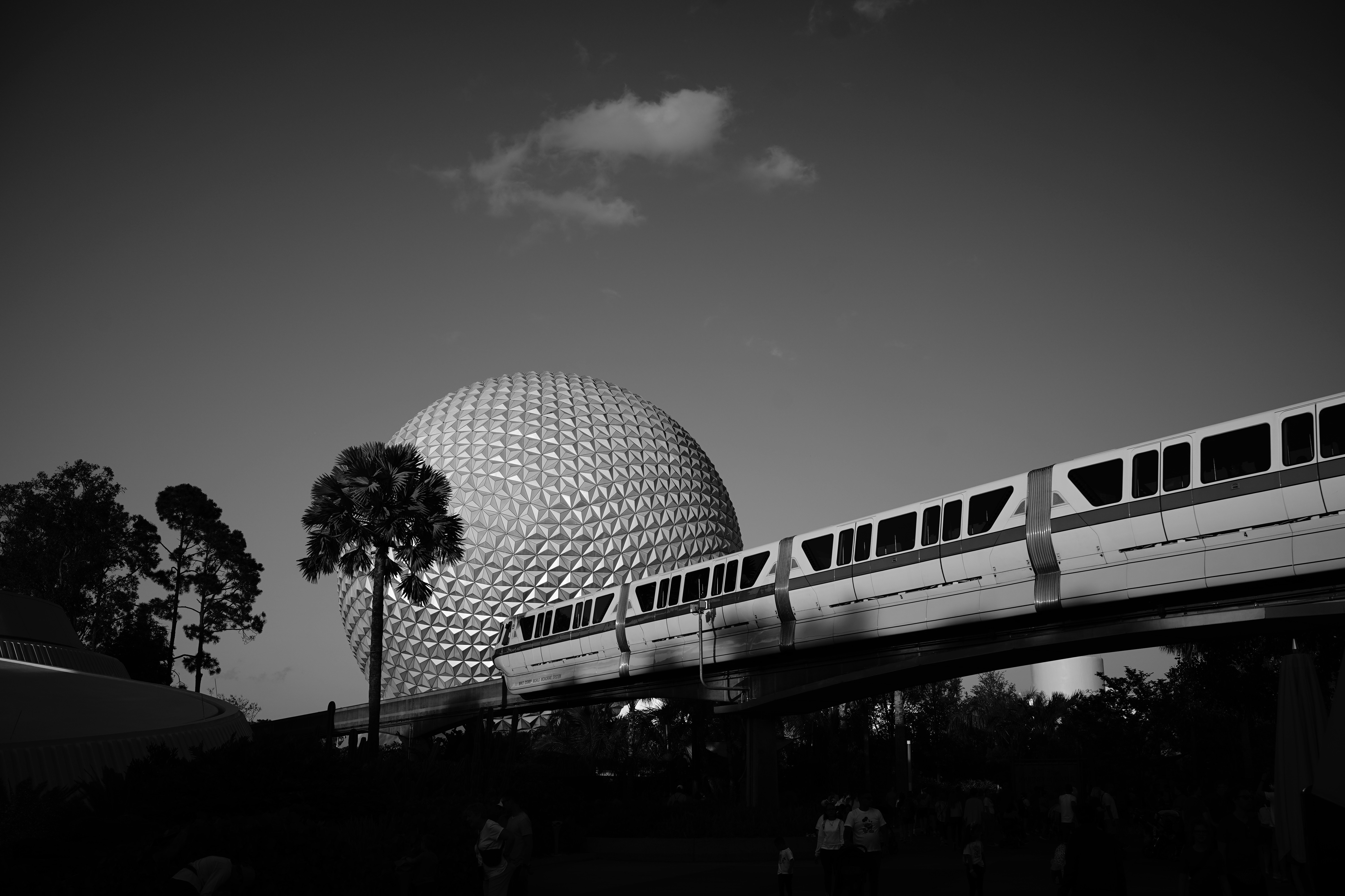 a monorail passing by a spaceship like building