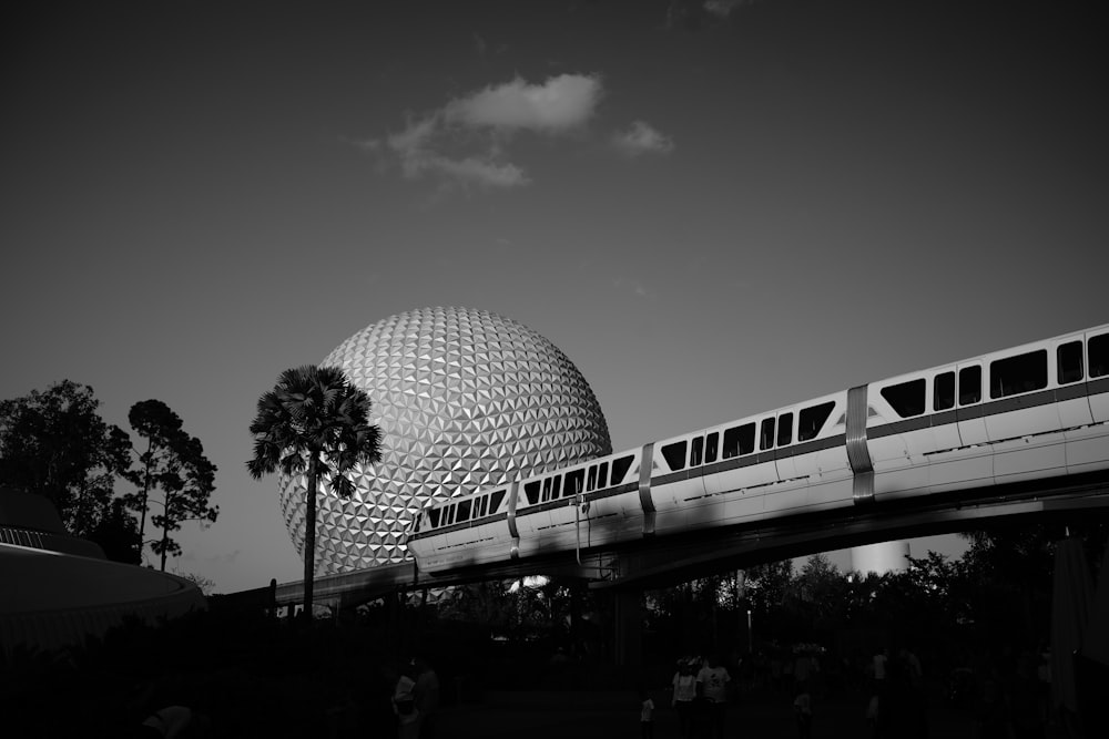 a monorail passing by a spaceship like building