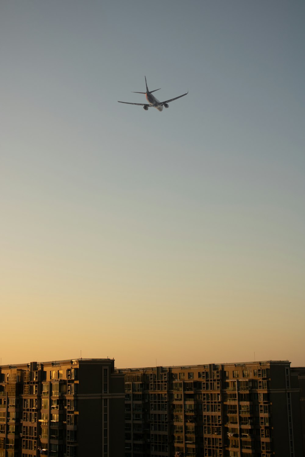 an airplane flying over a city at sunset