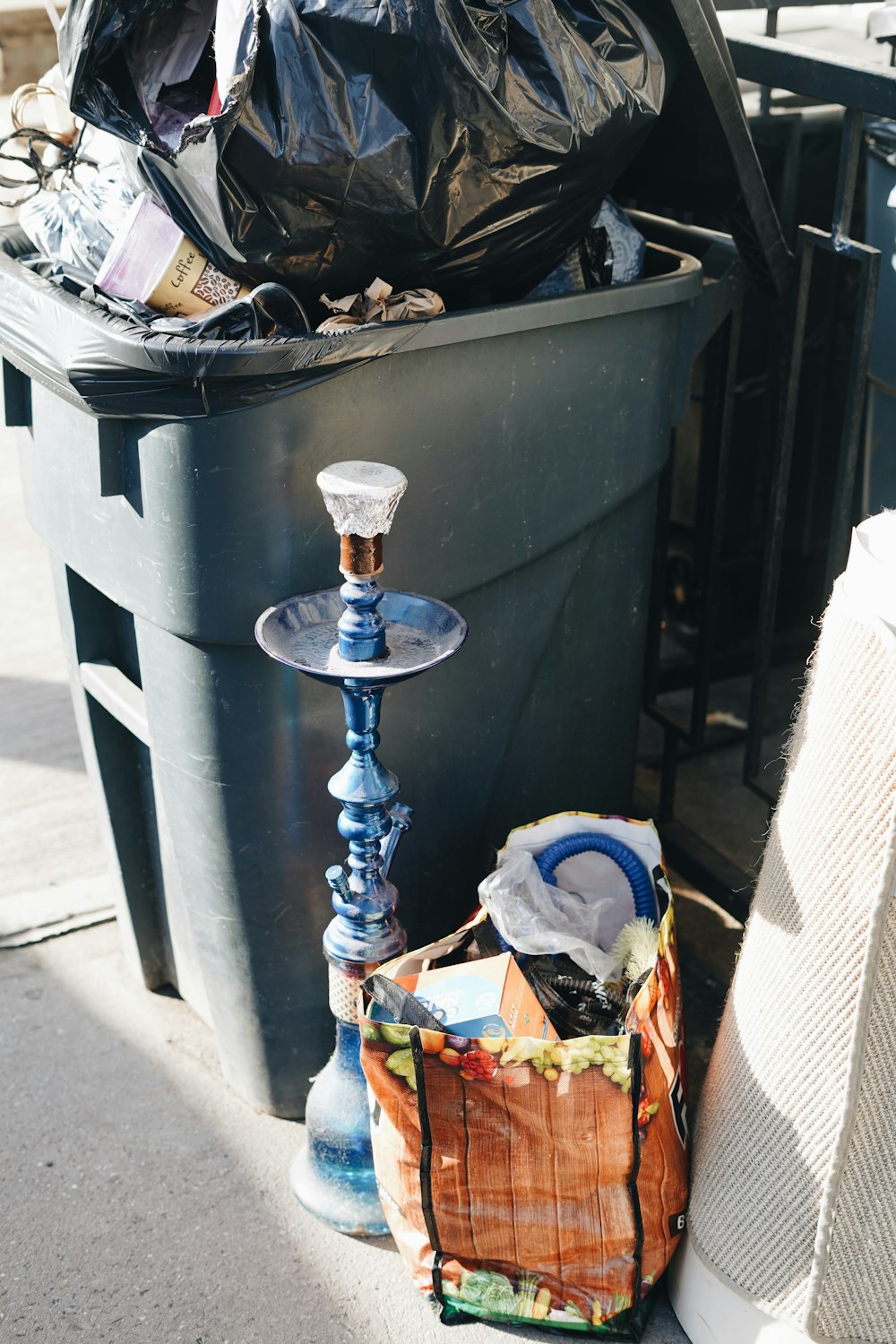 a trash can sitting next to a trash can