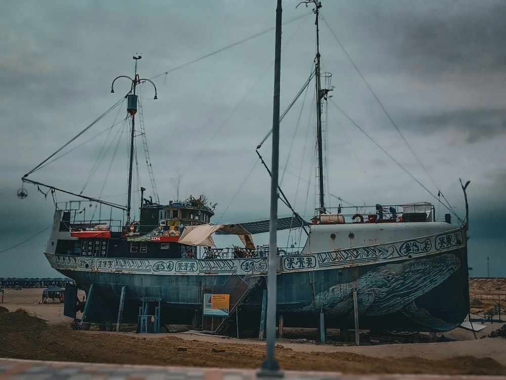 a large boat sitting on top of a sandy beach