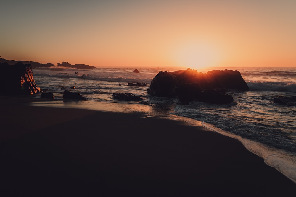 El sol se está poniendo sobre el océano y las rocas