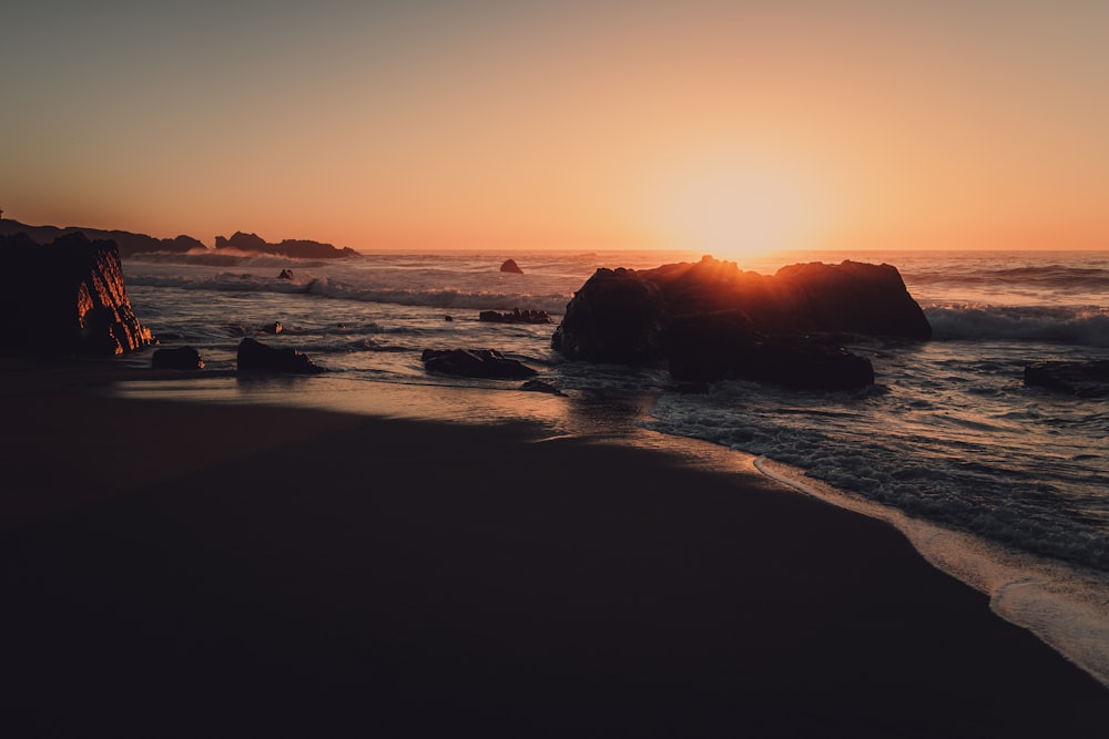 Il sole sta tramontando sull'oceano e sulle rocce